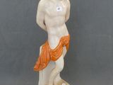figurine of a man holding a fish on a rock