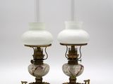 paire de lampes à huile anciennes avec des abat-jours en verre blanc sur des socles dorés