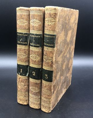 trois vieux livres posés l'un sur l'autre sur une table