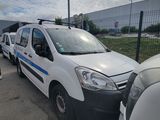 une camionnette blanche garée dans un parking à côté d'autres voitures