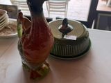 une figurine de canard posée sur une table, à côté d'une assiette de nourriture
