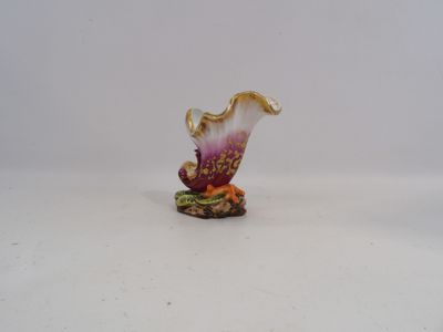 a small figurine of a flower on a white surface