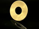 une bague en or sur une surface noire, avec un reflet