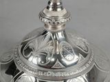 a silver cup that is sitting on top of a silver plate
