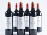 six bottles of red wine lined up in a row on a white surface