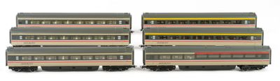 several toy trains are lined up in a row on a white surface