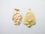 two gold pendants, one with a face and the other with a face