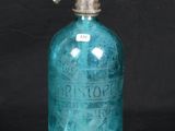 an old blue glass bottle with a metal pump on a black background