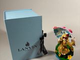 a small figurine of a woman with an umbrella next to a blue box