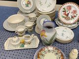 many plates and cups on a table with a blue tablecloth