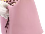 pink leather handbag with white gloves on a white background