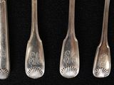 five silver spoons and a spoon knife on a black surface