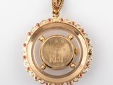 an image of a gold pendant with a coin inside of it