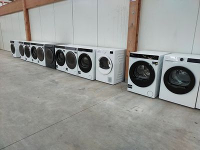 Plusieurs machines à laver sont alignées les unes à côté des autres dans un entrepôt