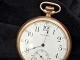 une montre de poche en or posée sur un tissu noir