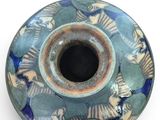 a blue and green vase on a white surface