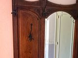 a wooden cabinet with a mirror on it in a room