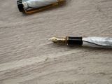 two pens that are sitting on a wooden table