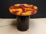 a small table with a black base and a yellow and red top