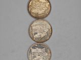three different coins sitting on top of each other on a table