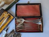 a box of silverware on a table with other silverware in it