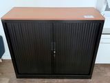 une armoire noire et marron avec des portes et des tiroirs dans une pièce