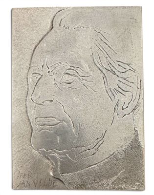 un gros plan d'une plaque métallique sur laquelle figure le visage d'un homme
