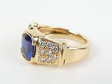 a close up of a gold ring with a blue stone and diamonds