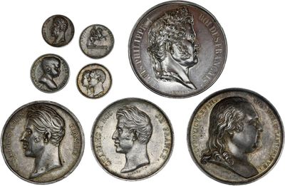 a close up of a group of silver coins on a white surface