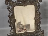 an antique silver picture frame with a picture of a castle in the background