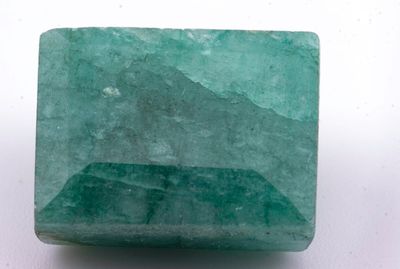 gros plan d'une pierre d'émeraude verte sur une surface blanche