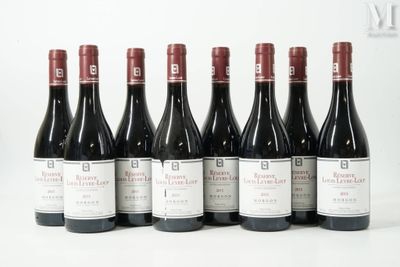 six bouteilles de vin rouge sont alignées sur une surface blanche