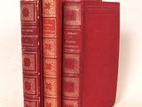 Deux livres rouges sont empilés l'un sur l'autre sur une surface blanche