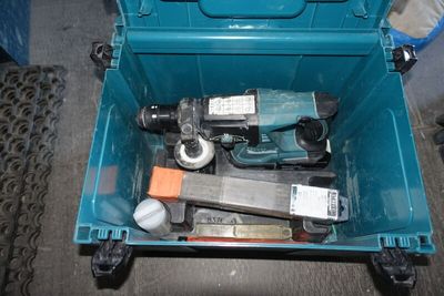 une boîte à outils bleue avec des outils sur le sol