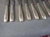 six knives and a knife holder on a table