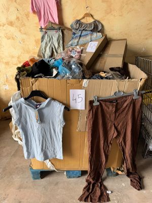 un tas de vêtements posé sur un carton dans une pièce