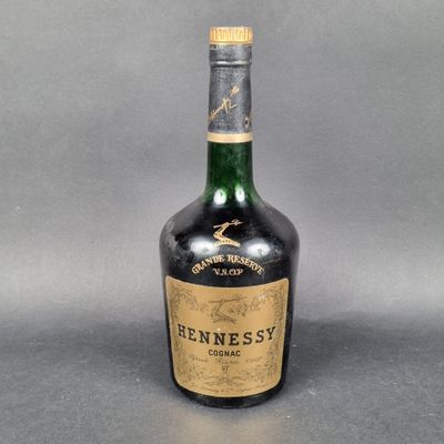 une vieille bouteille de whisky Hennesby sur fond gris