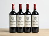 three bottles of red wine are lined up on a wooden table