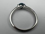a close up of a silver ring with a blue stone