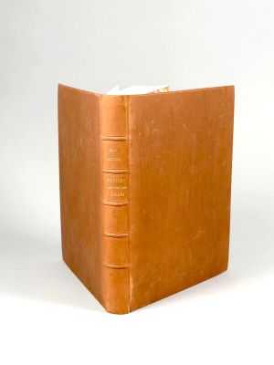 un livre brun posé sur une table blanche