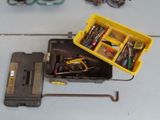 une boîte à outils jaune contenant des outils, posée sur une table