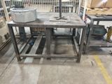 a metal table with a bucket on it in a warehouse
