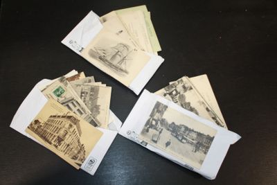 cinq vieilles cartes postales posées sur une table noire, avec l'image d'un train