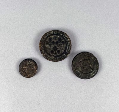 three ancient coins are shown on a white surface