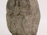 a stone sculpture of an owl sitting on a rock