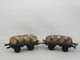 two toy train cars with barrels on them on a white surface