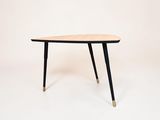 une image représentant une table en bois aux pieds noirs sur fond blanc
