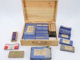 a wooden box filled with blue books and a box of matches