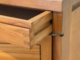 a close up of a wooden dresser with a drawer in it