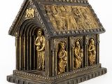 an image of a gold and black statue of a church